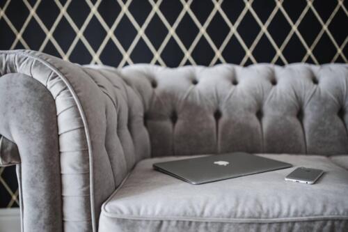 kaboompics Silver laptop and an iPhone on a grey sofa(1)